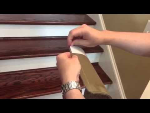 Hands are shown installing a stair tread anti-slip strip on a wooden staircase.